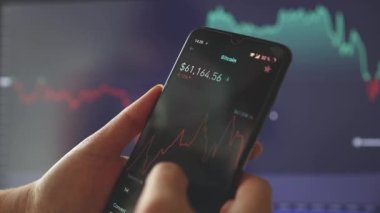 İşadamı, borsa uygulamasını cep telefonunda işlem yapmak için kullanıyor. Yatırım stratejisi