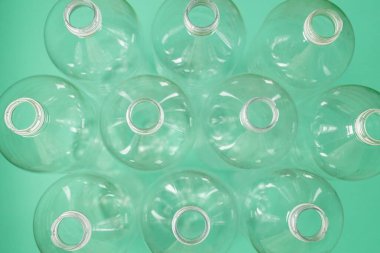 Yeşil zemin üzerinde boş plastik PET su şişeleri