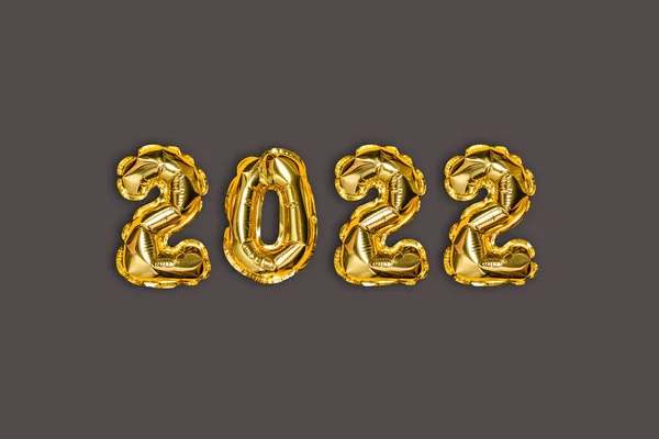 2022 goldene Folie Luftballons Dekor und Weihnachtsschnee mit Kopierraum auf einem braunen Hintergrund. Neujahrskonzept — Stockfoto