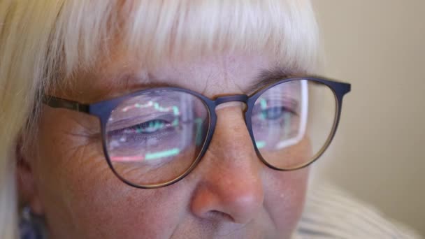 Focused businesswoman eye looking monitor, surfing Internet. Female with glasses eyes looking at the monitor in dark room. Close up — Stock Video