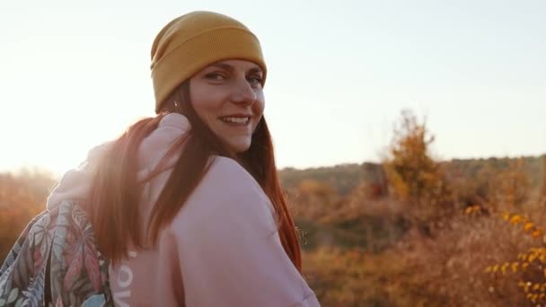 Gyönyörű turista utazó lány egy sport hátizsák utazik át a havas természet a napnyugta sugarai — Stock videók