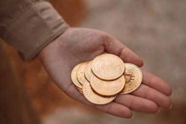 Tanımlanamayan kadın eli çok miktarda bitcoin para gösteriyor.