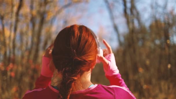 Mujer de carrera activa con auriculares blancos corriendo al aire libre en la naturaleza autimn caída para lograr sus objetivos de fitness deportivo. Fitness concepto de estilo de vida saludable. — Vídeos de Stock