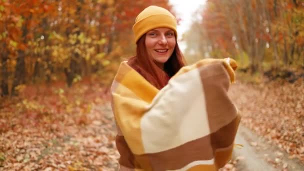 Portrét šťastné mladé ženy nosí podzimní čepici a šátek na podzim v parku, útulné teplé oblečení — Stock video