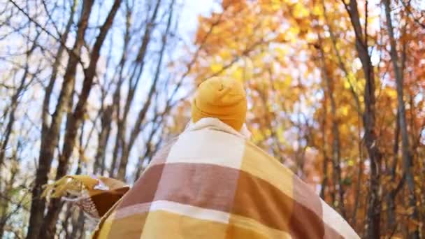 Mujer madura en ropa elegante brillante con una larga bufanda amarilla gira alrededor disfrutando de otoño callejón dorado fuera, teniendo ventilador durante la temporada de otoño — Vídeos de Stock