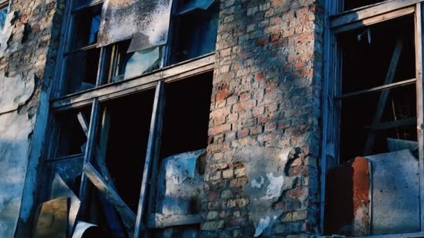 Ceglana fasada opuszczonego starego budynku z oknami w promieniach słońca jesienią. Stare ruiny fabryki — Wideo stockowe