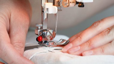 Dikiş makinesi ayağıyla iğne, doğa kumaşı diker.