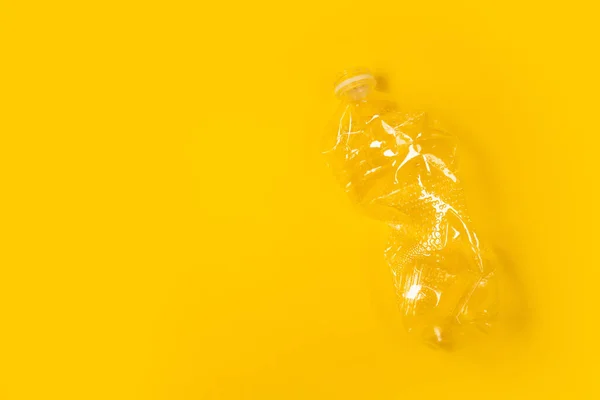 折皱后使用的空塑料瓶与黄色背景隔离 顶部视图 复制空间 塑料废物背景 — 图库照片