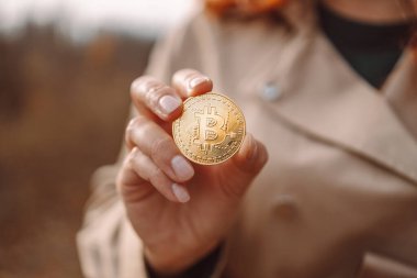 Altın Bitcoin bir iş kadınının açık havada elinde. Kripto para birimi kavramı