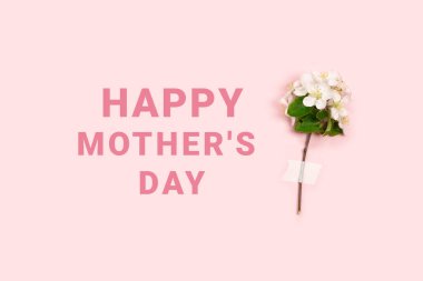 Anneler günün kutlu olsun. Beyaz narin çiçek dalı pembe arka planda metin için yeri olan