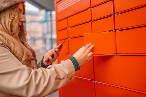 Mujer que usa una máquina automatizada de autoservicio o un casillero para depositar el paquete para almacenamiento — Foto de Stock