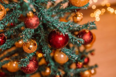 Kırmızı Noel topları Noel ağacını süslüyor, Bokeh çelenkleri. Seçici odak.