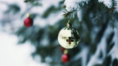Kırmızı altın oyuncaklarla süslenmiş, karla kaplı Noel ağacını kapatın. Mutlu Noeller ve mutlu tatiller