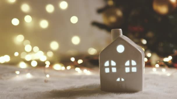 Feliz año nuevo 2022 tema con pequeña decoración de la casa modelo de juguete en hermoso fondo de luces. Enfoque selectivo, árbol de Navidad — Vídeos de Stock