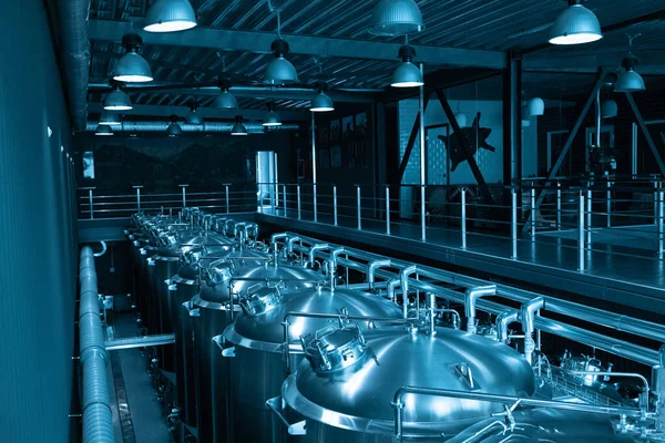 Industrieel interieur van moderne ambachtelijke brouwerij met chromen cilindrische metalen biertanks. Particuliere microbrouwerij. — Stockfoto