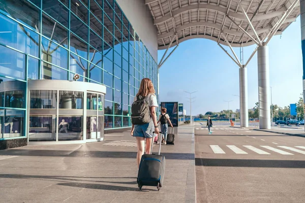 Volwassen vrouw toerist met handbagage koffer en rugzak gaat naar het vliegveld voor de reis. Vrouw klaar om aan boord te gaan. Verbazingwekkende zomeravonturen — Stockfoto