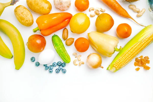 Olika friska färska grönsaker, frukt och nötter på en vit bakgrund. Grönsaker, hälsosam vegansk mat — Stockfoto