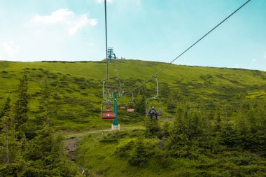 Funicular in the mountains in the warm season. Cable car to the national park with blue sky on background