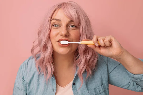 幸せな笑顔の女性はピンクの背景に歯ブラシで健康な歯を磨く衛生コンセプト — ストック写真