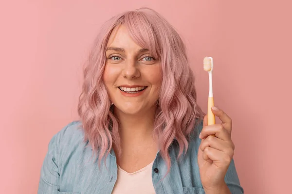 幸せな笑顔の女性は ピンクの背景に孤立歯ブラシできれいに白い歯を持っています衛生コンセプト — ストック写真