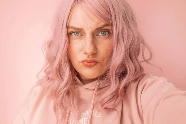 年轻、情绪化、愤怒的女人在粉色背景下拍照时的特写 — 图库照片