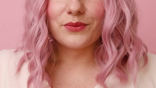 Positive dreamy young pink hair woman sending air kiss to camera isolated over pink background — Stock Video