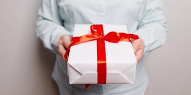 Gömlekli bir iş adamı elinde güzel bir hediye kutusu, kadın hediyesi, Noel tatili ve karşılama sezonu konsepti tutuyor.