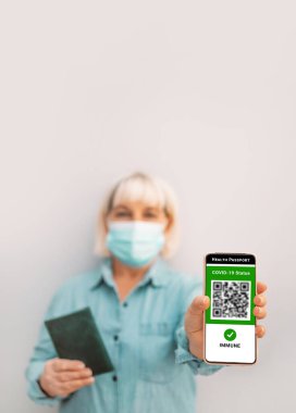 Cep telefonundaki dijital covid-19 aşı sertifikası. Covid-19 kontrol. Coronavirus aşılanmış insanlar kamusal alana giriş yapan QR kod ziyaretçilerini tarıyor.