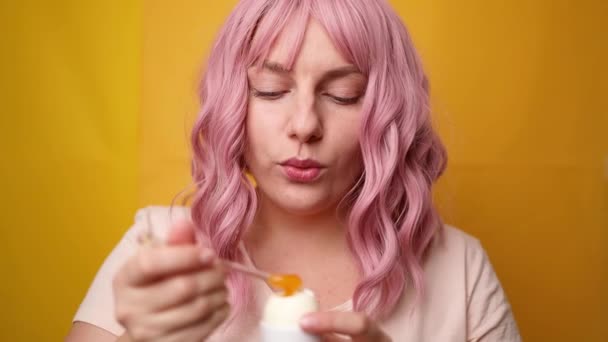Ritratto di gioiosa giovane donna che si diverte a mangiare uova di pollo inceppate su sfondo stele giallo — Video Stock