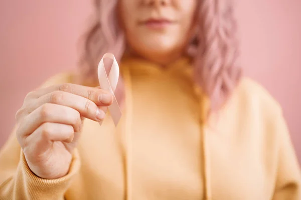 Ausgeschnittenes Foto einer Frau in einem gelben Pullover mit einem rosafarbenen Satinband, das den Internationalen Brustkrebstag symbolisiert. Rosenkonzept vom Oktober — Stockfoto