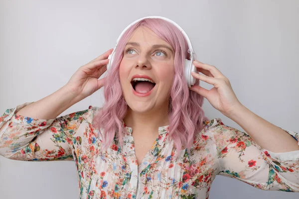 かなりピンク髪ヨーロッパの女性笑顔でリッスンお気に入りのメロディー絶縁上グレーの背景 — ストック写真