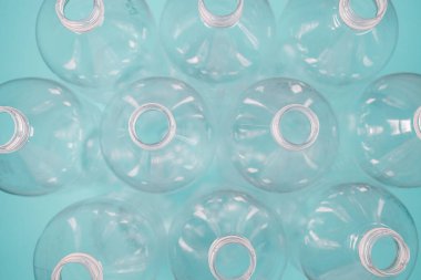 Mavi arka planda kullanılmış plastik şişeler. Ekoloji problemi. Üst Manzara. Çöpü, geri dönüşümü, plastiği yeniden kullan.