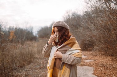 Hasta genç kadın hapşırıyor, öksürüyor, dışarıdaki soğuk algınlığına karşı alerjisi var.