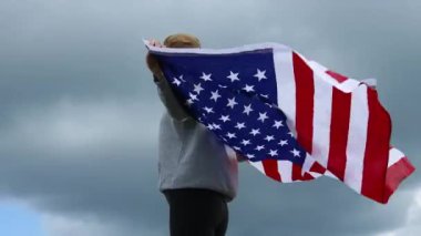 - Zafer. Mutlu vatansever genç kadın elinde bir Amerikan bayrağı salladı. Gezgin kız macera gezintilerinden zevk alıyor açık havada aktif yaşam tarzı