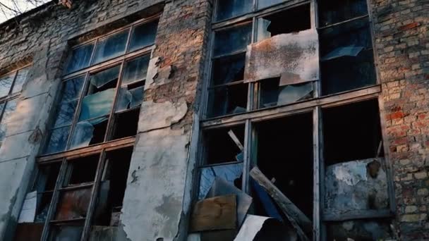 Backsteinfassade eines verlassenen Altbaus mit Fenstern im Sonnenlicht — Stockvideo
