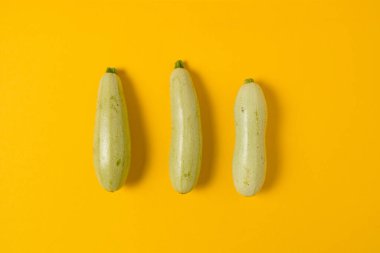 Sarı arka planda yeşil kabak ya da sebze iliği deseni. Üst görünüm.