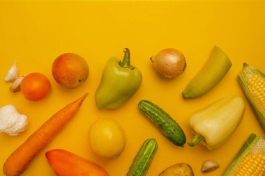 Parlak sarı arka planda çeşitli yararlı ve sağlıksız gıdalar. Üst manzara, düz yatış. Diyet kavramı