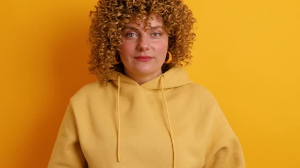 Glad ung 30-talskvinna gör valet mellan hälsosam och skräpmat över ljusa gula färg bakgrund. Hälsosam kost koncept. — Stockvideo