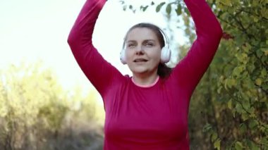 Beyaz kablosuz kulaklıklı spor formundaki kadın kırsal bir yolda çalışıyor. Koşu ve sağlıklı yaşam tarzı..