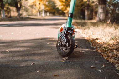 Şehir merkezinde yağmur damlaları olan kiralık modern elektrikli scooter ekonomik araç. Sıfır emisyon yeşil