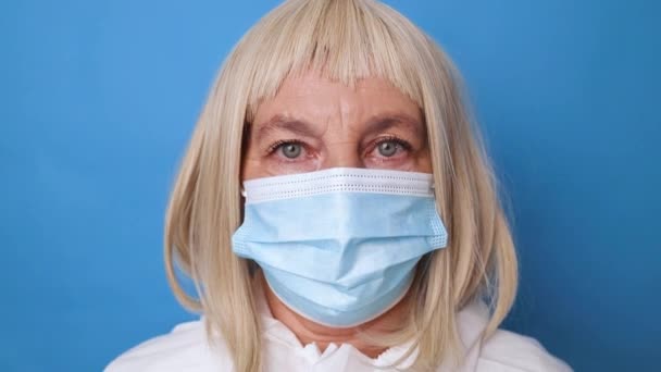 Porträtt av kvinnlig läkare eller sjuksköterska bära blå handskar bär medicinsk mask på sjukhus. — Stockvideo