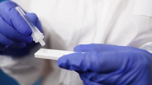 Primer plano de un médico en traje de PPE médico sostiene la prueba COVID-19 coronavirus PCR — Vídeo de stock