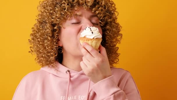 Primer retrato de una hambrienta mujer de 30 años mordiendo pastel de crema. Romper la dieta. — Vídeos de Stock