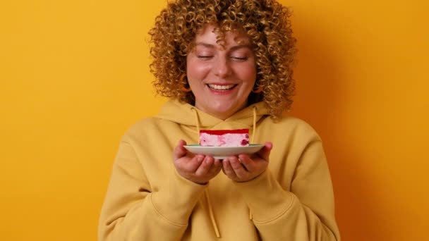 30s mano de mujer con sabroso cupcake sobre fondo de color amarillo brillante — Vídeo de stock