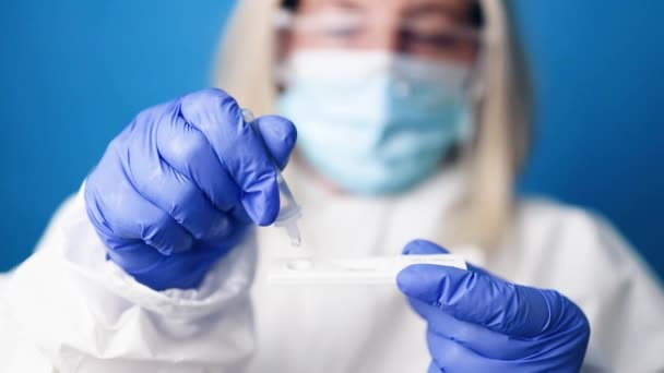 Närbild av en läkare i medicinsk PPE kostym håller COVID-19 coronavirus PCR test — Stockvideo