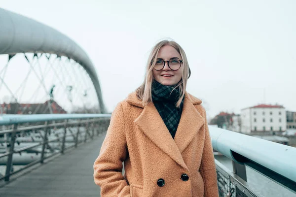 Estilo de vida retrato de uma mulher loira caucasiana andando na ponte na rua na cidade de Cracóvia — Fotografia de Stock