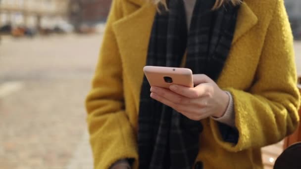 Primo piano delle mani femminili donna utilizzando uno smartphone moderno in strada città autunno. — Video Stock