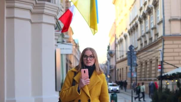 Una joven periodista de 30 años que usa el teléfono en la calle City. Concepto de medios sociales, prensa, noticias, información — Vídeo de stock