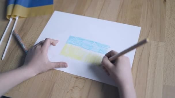 Mains d'enfants avec crayon de couleur jaune et bleue dessinant le drapeau ukrainien à l'intérieur à la maison — Video