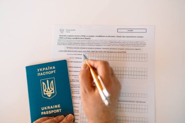 Beyaz masadaki PESEL belgesiyle kadın el yazısı